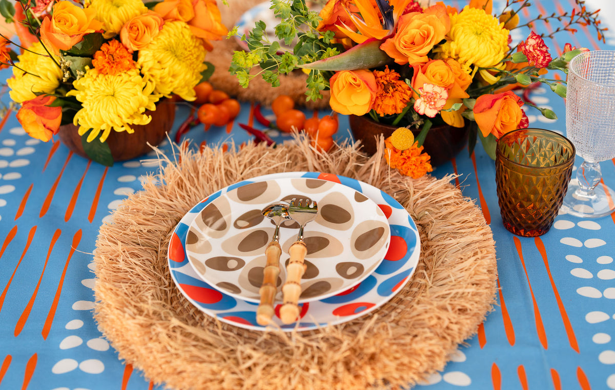 Colourful COCOLILI place setting on blue and orange printed linen